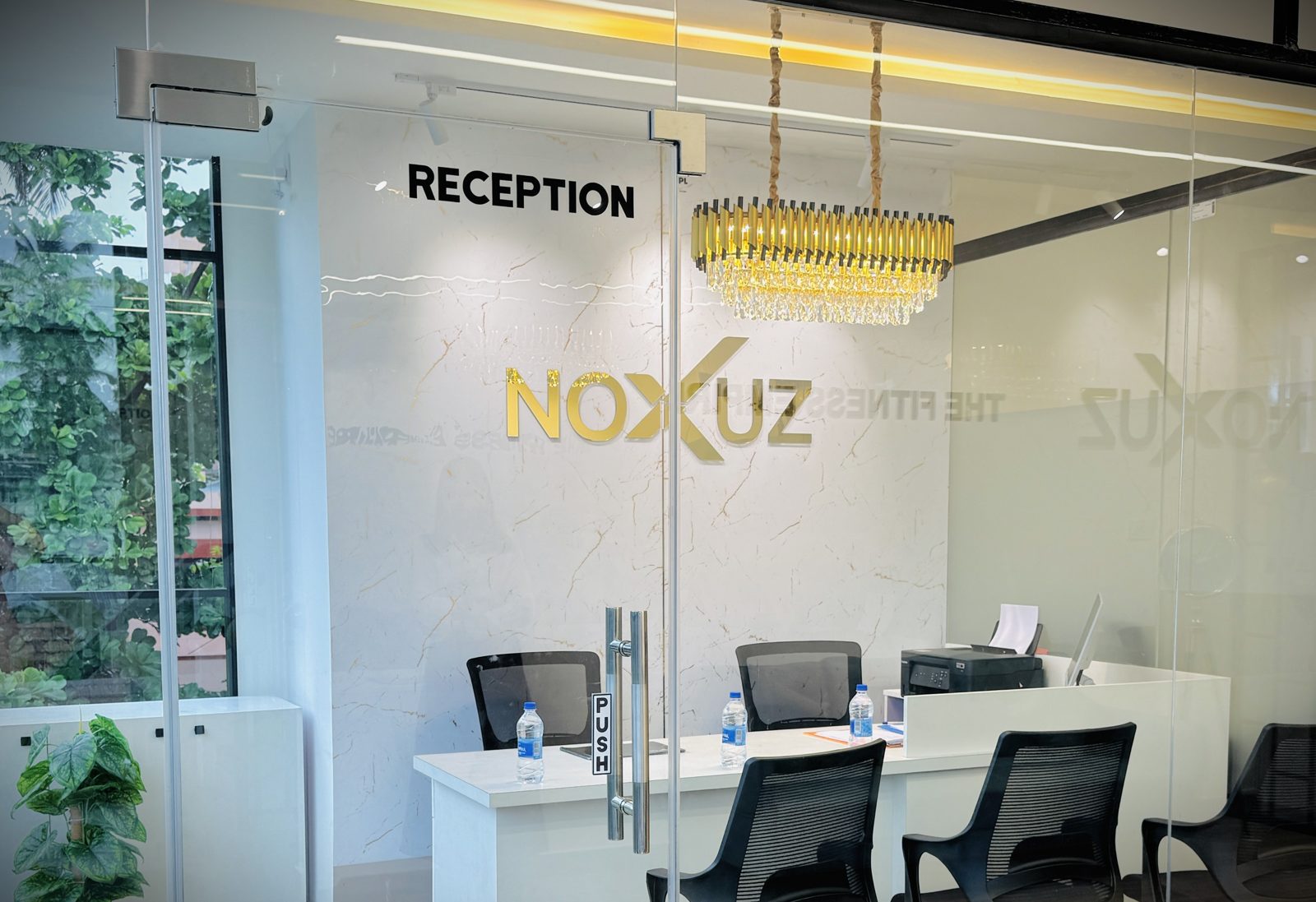 Reception lobby with gold NOXUZ wall mark and chandelier